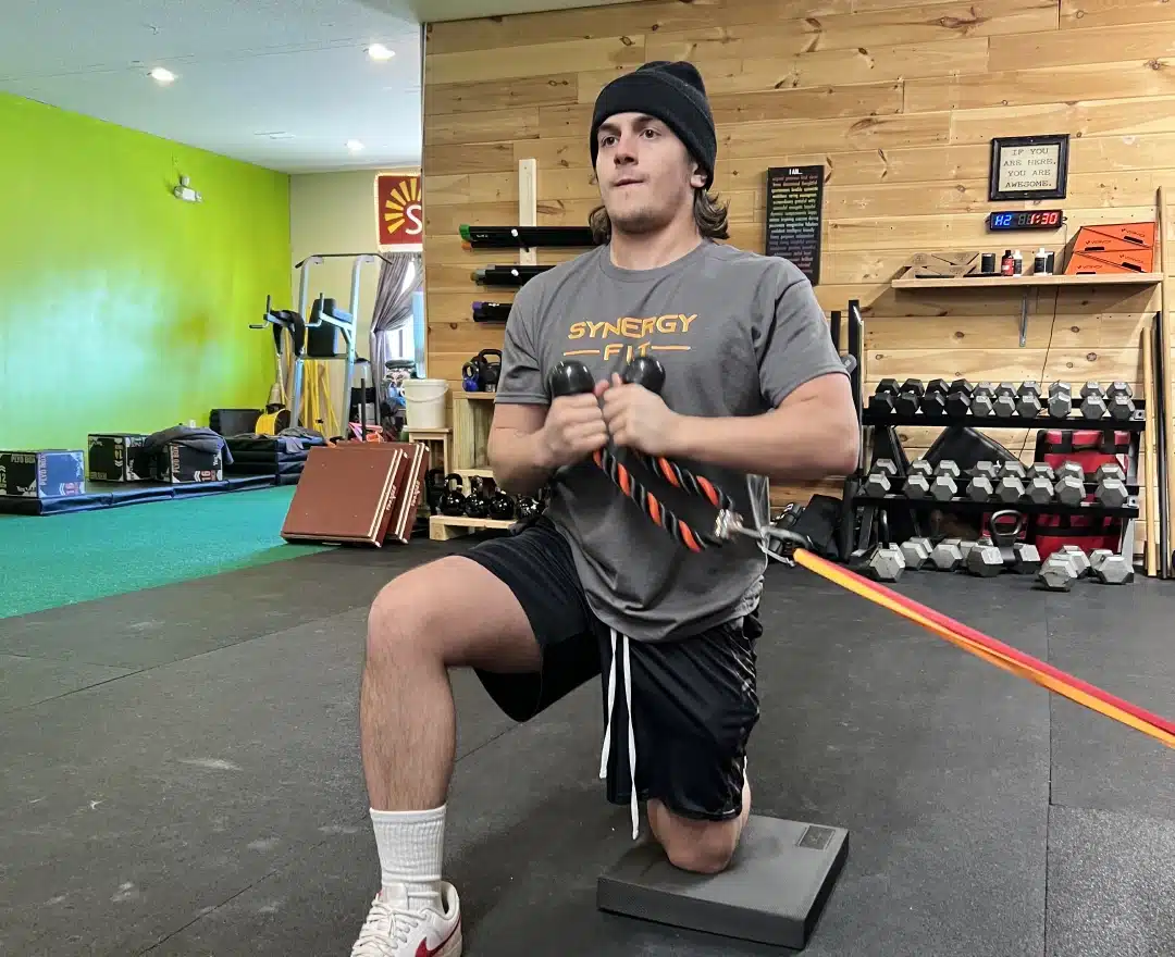 A young athlete working through a resistance-band split squat