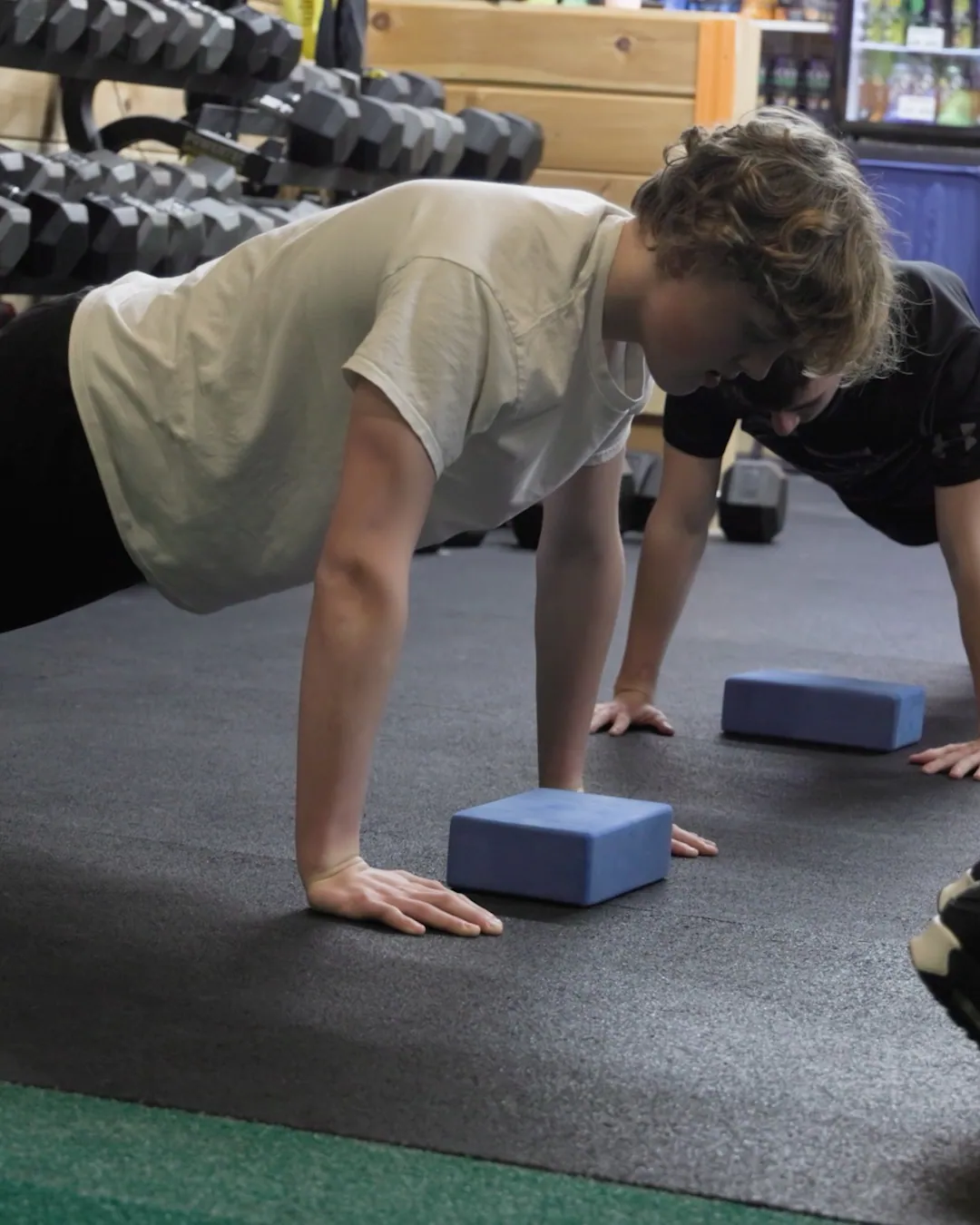 Two members holding a plank on yoga blocks