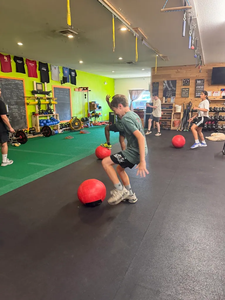 Young athletes working with medicine balls in front of the lime wall